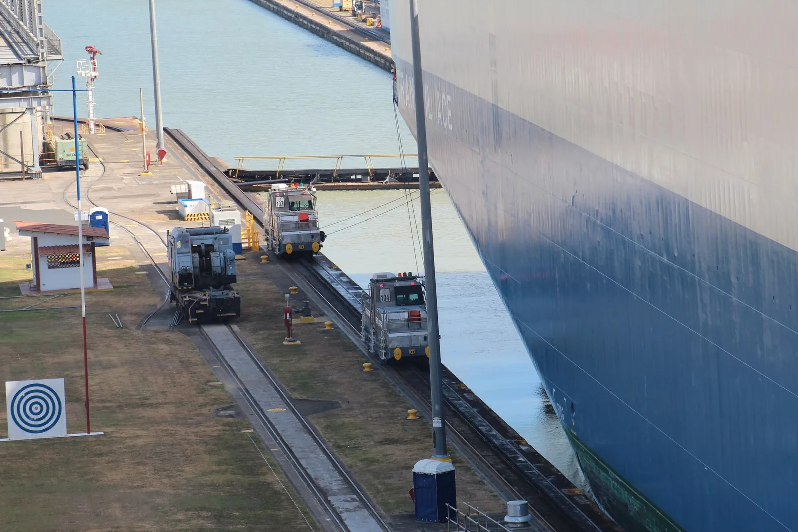 Locomotives (mulas) sur les rails d'une écluse du canal de Panama, à côté de la coque d'un grand navire