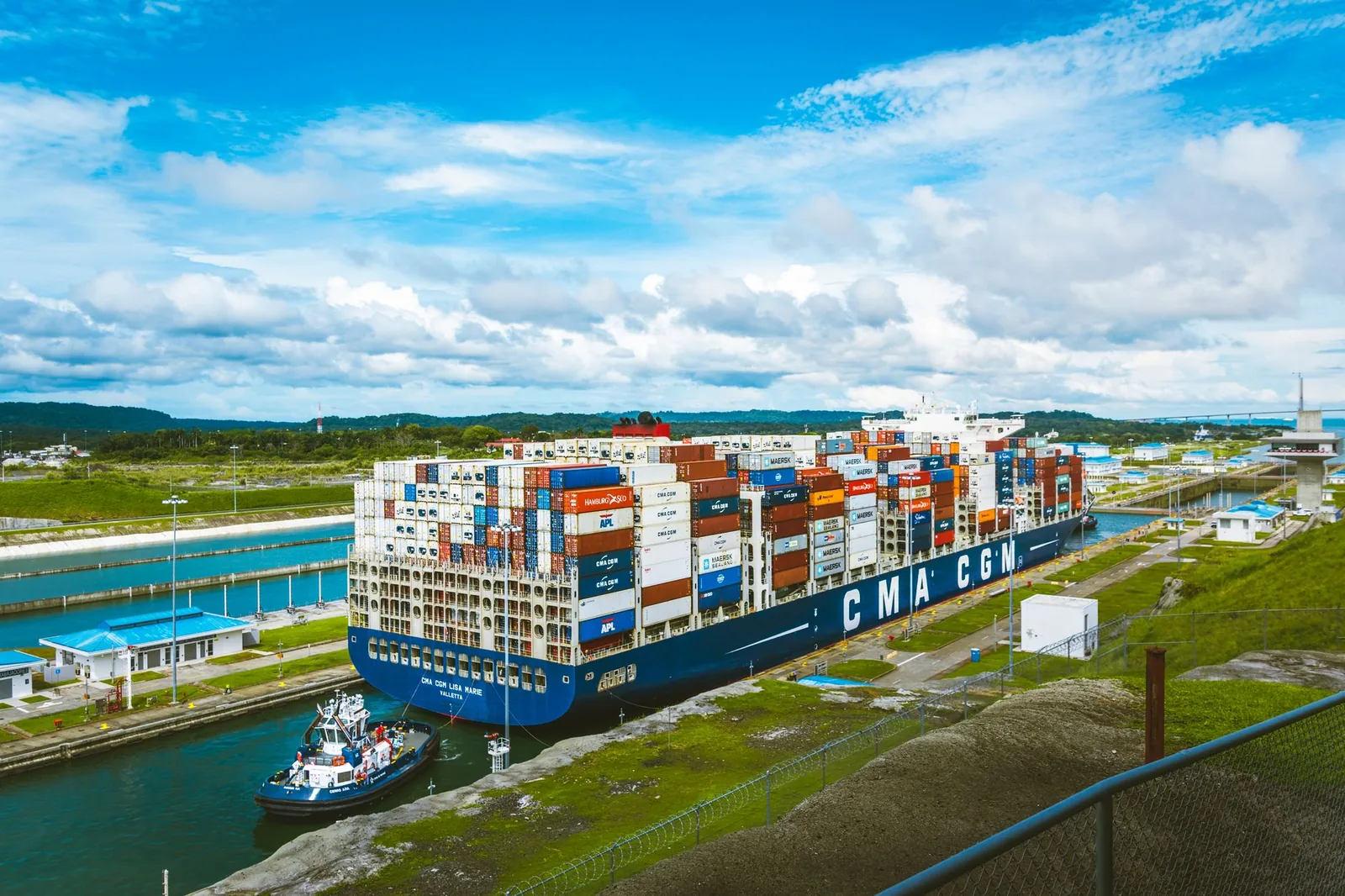 Porte-conteneurs guidé par un remorqueur dans les écluses d'expansion du canal de Panama