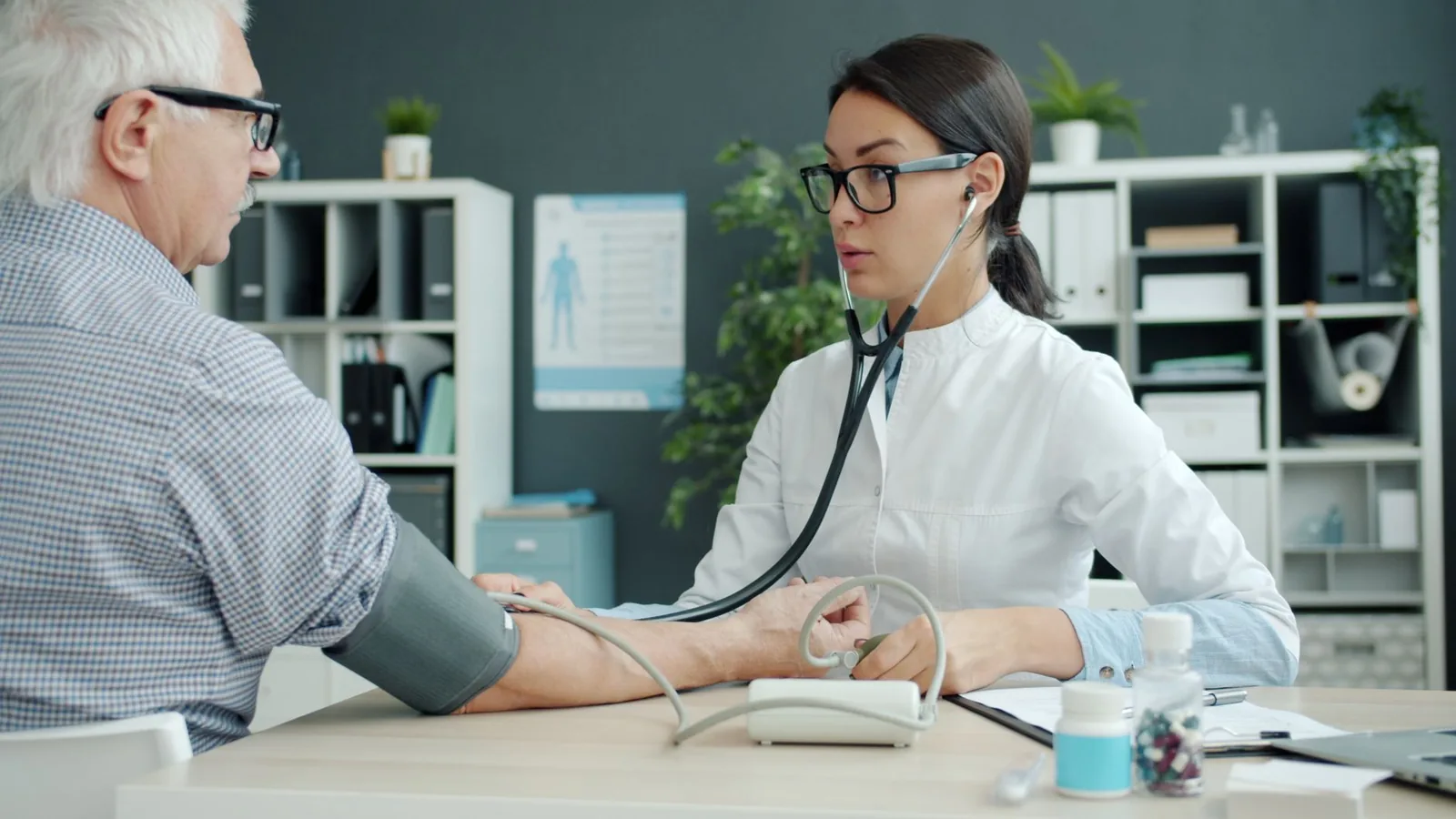 Médecin prenant la tension d'un patient âgé lors d'une consultation en cabinet