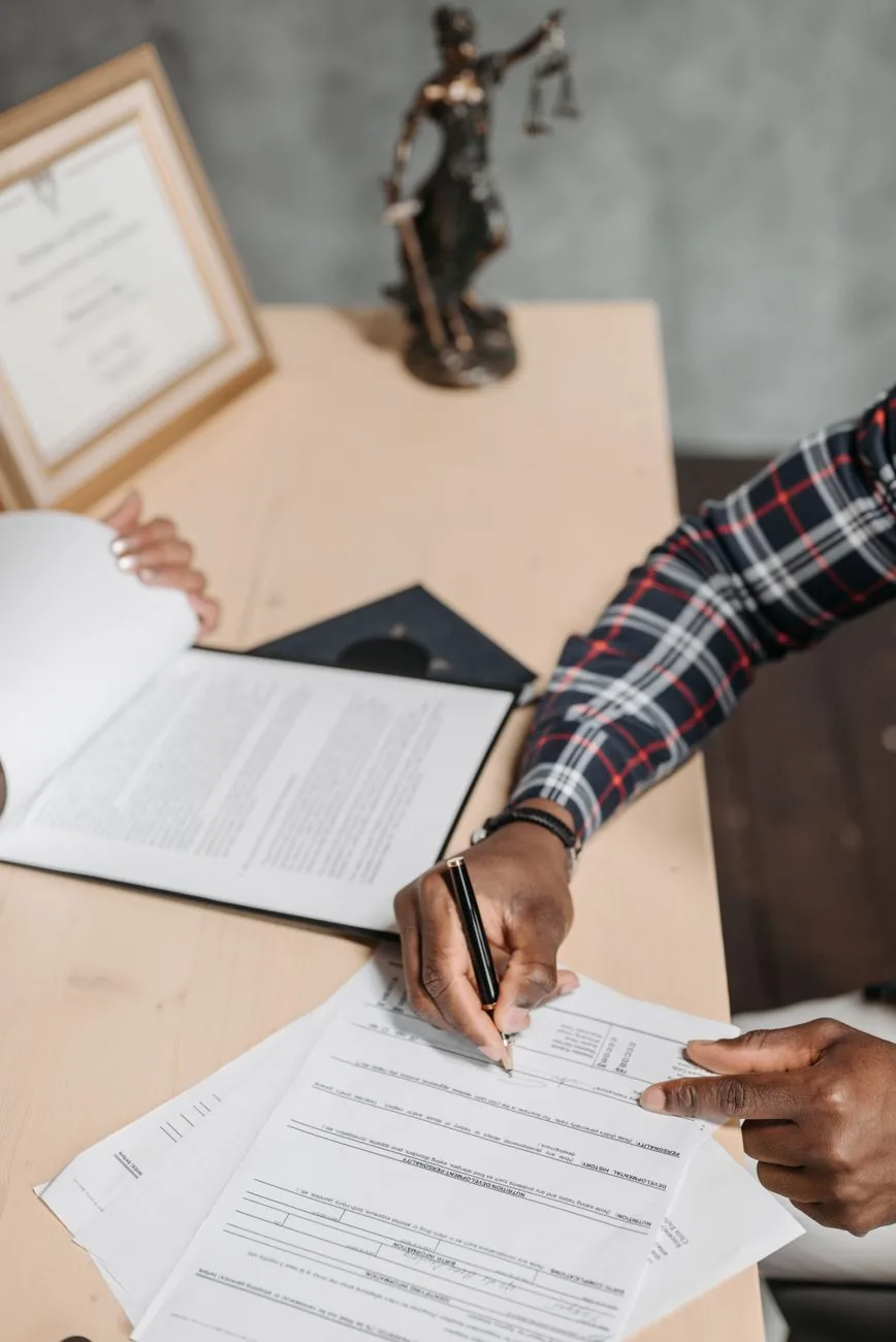 Signature de documents officiels notariés sur un bureau d'étude juridique
