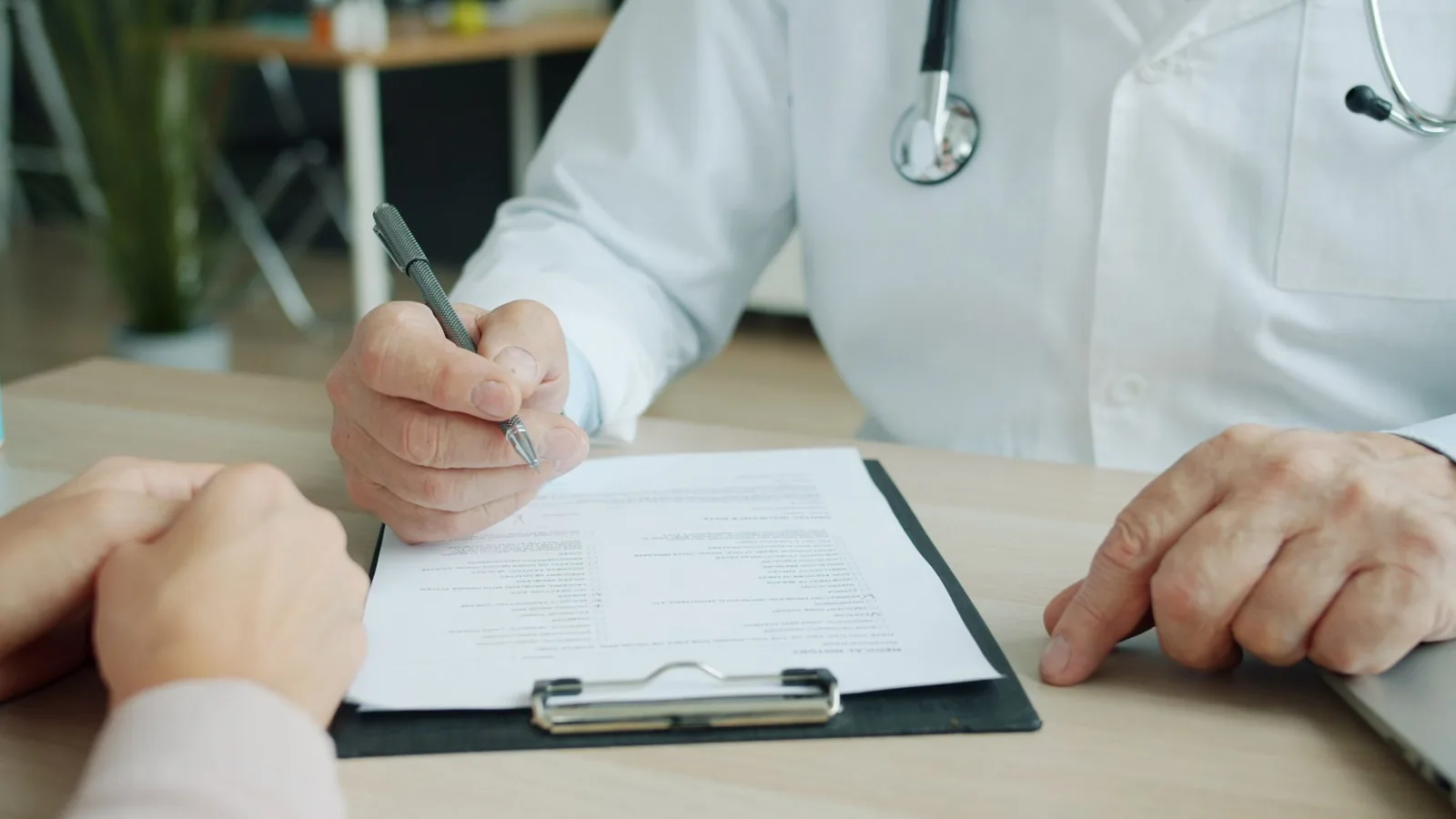 Médecin remplissant un questionnaire d'antécédents médicaux face à un patient