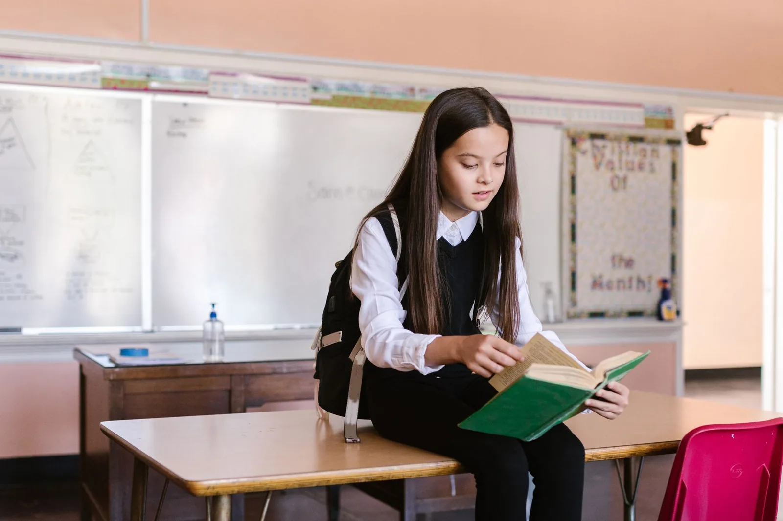 Élève avec cartable lisant un livre en salle de classe, illustration