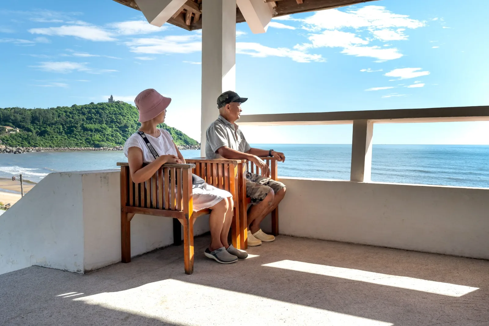 Couple de retraités assis sur une terrasse avec vue sur l'océan Pacifique