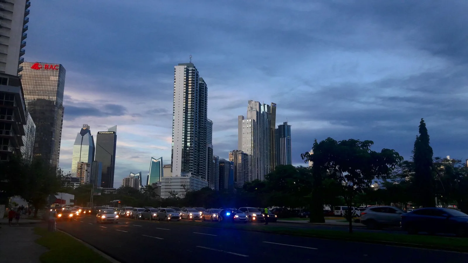 Circulation dense au crépuscule sur un grand boulevard de Panama City, gratte-ciel en arrière-plan